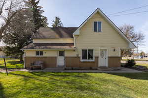 View of front facade with brick siding, a front lawn, and a shingled roof