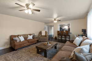 Living area with wood-type flooring, a textured ceiling, and a ceiling fan