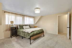 Bedroom featuring light colored carpet and baseboards