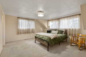 Bedroom with light carpet and a textured ceiling