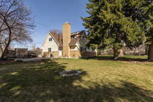Rear view of property featuring a chimney, a patio, a fire pit, and brick siding
