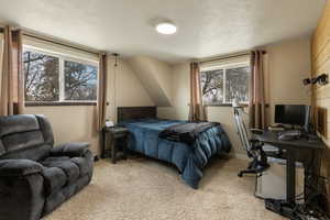 Carpeted bedroom with a textured ceiling and baseboards