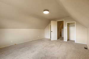 Bonus room featuring light colored carpet and baseboards