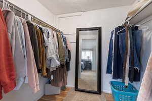 Walk in closet with light wood-style flooring