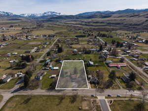 Aerial view of property and surrounding area featuring property parcel outlined and a mountain backdrop