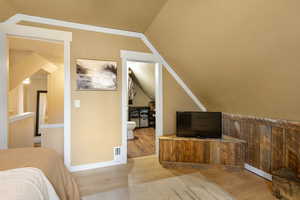 Bedroom featuring light wood-style flooring and lofted ceiling