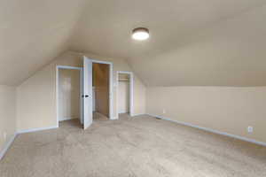 Bonus room featuring light colored carpet and baseboards