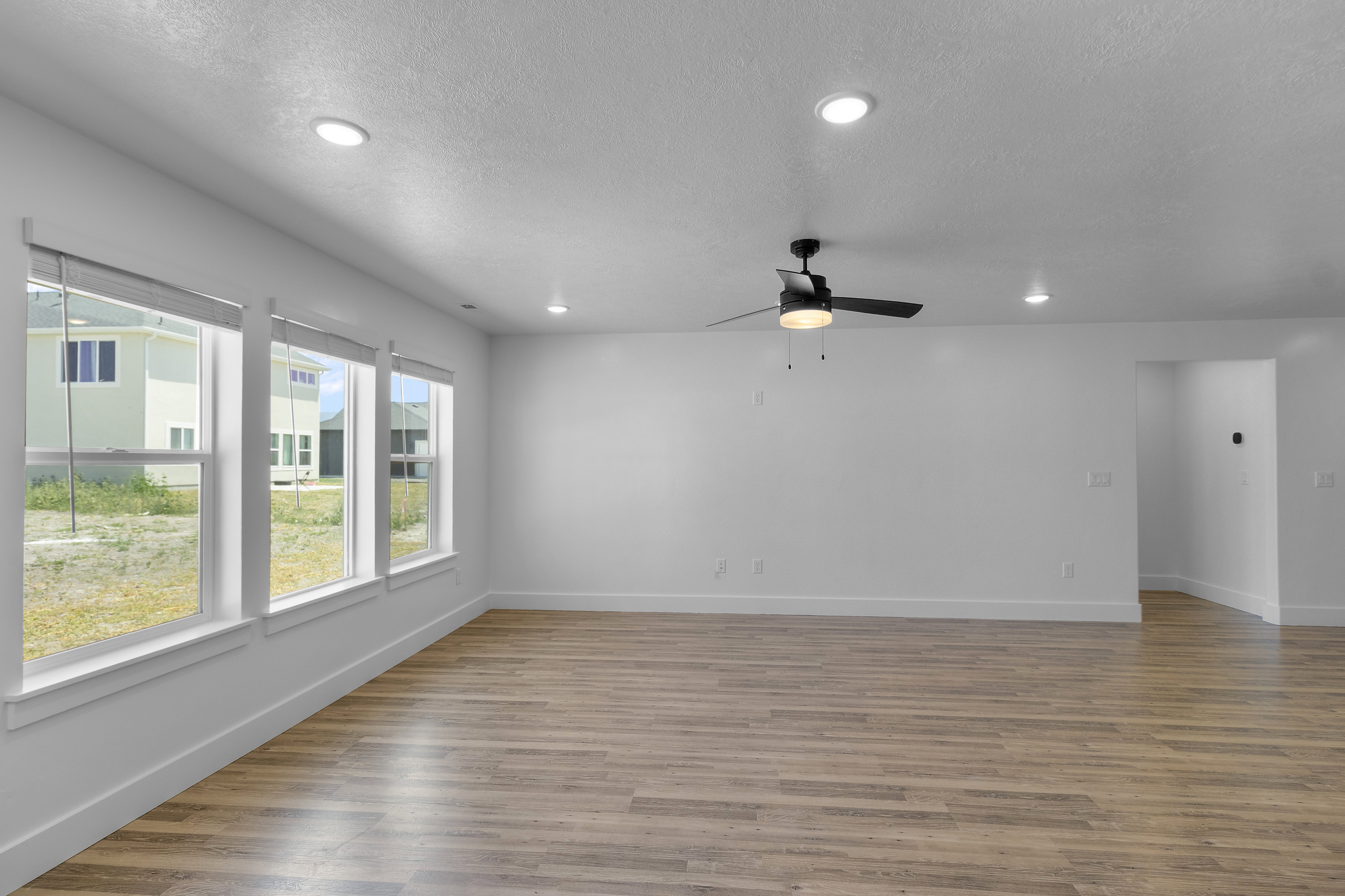 Spare room with light wood finished floors, ceiling fan, recessed lighting, and a textured ceiling