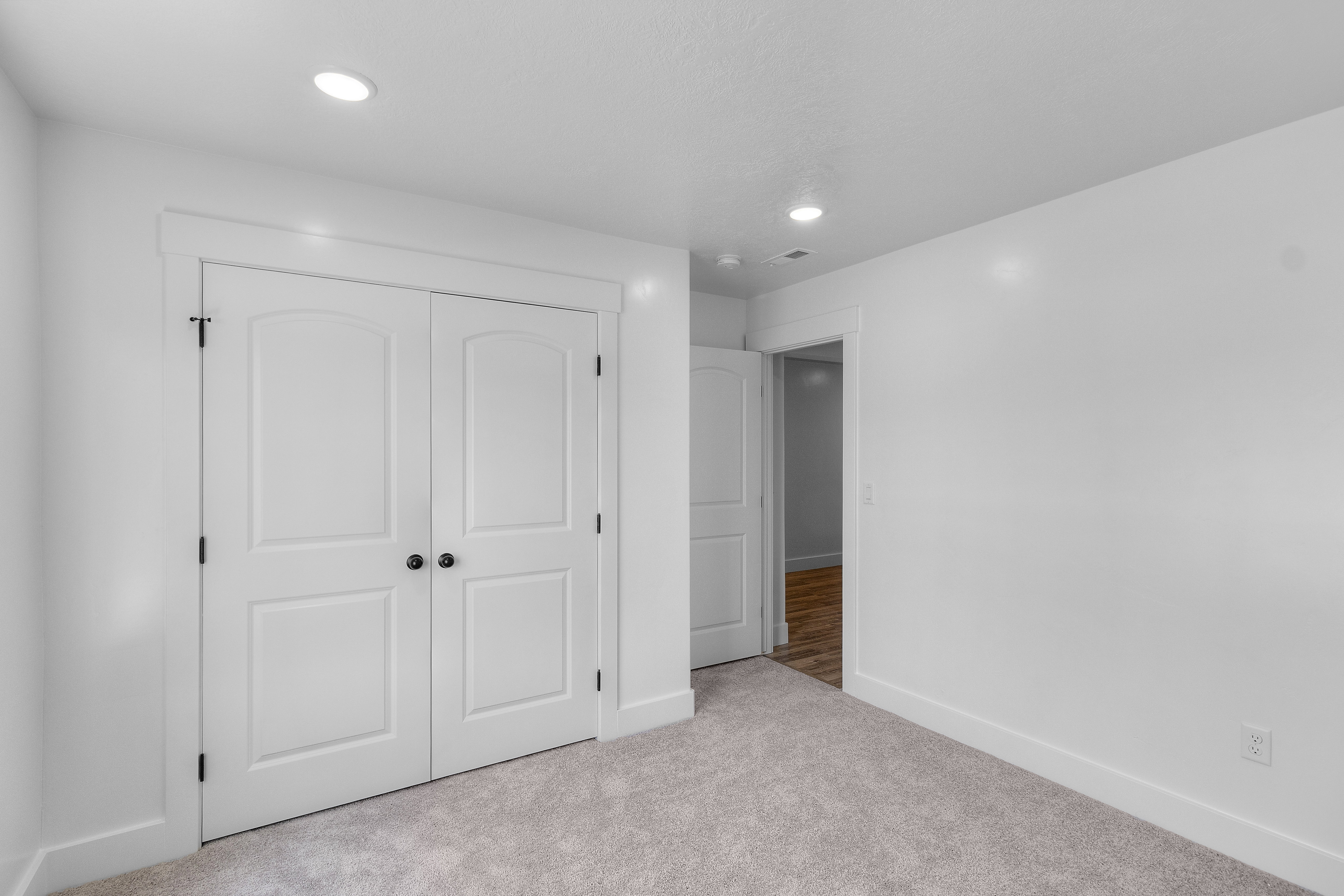 Unfurnished bedroom with light carpet, a closet, and recessed lighting