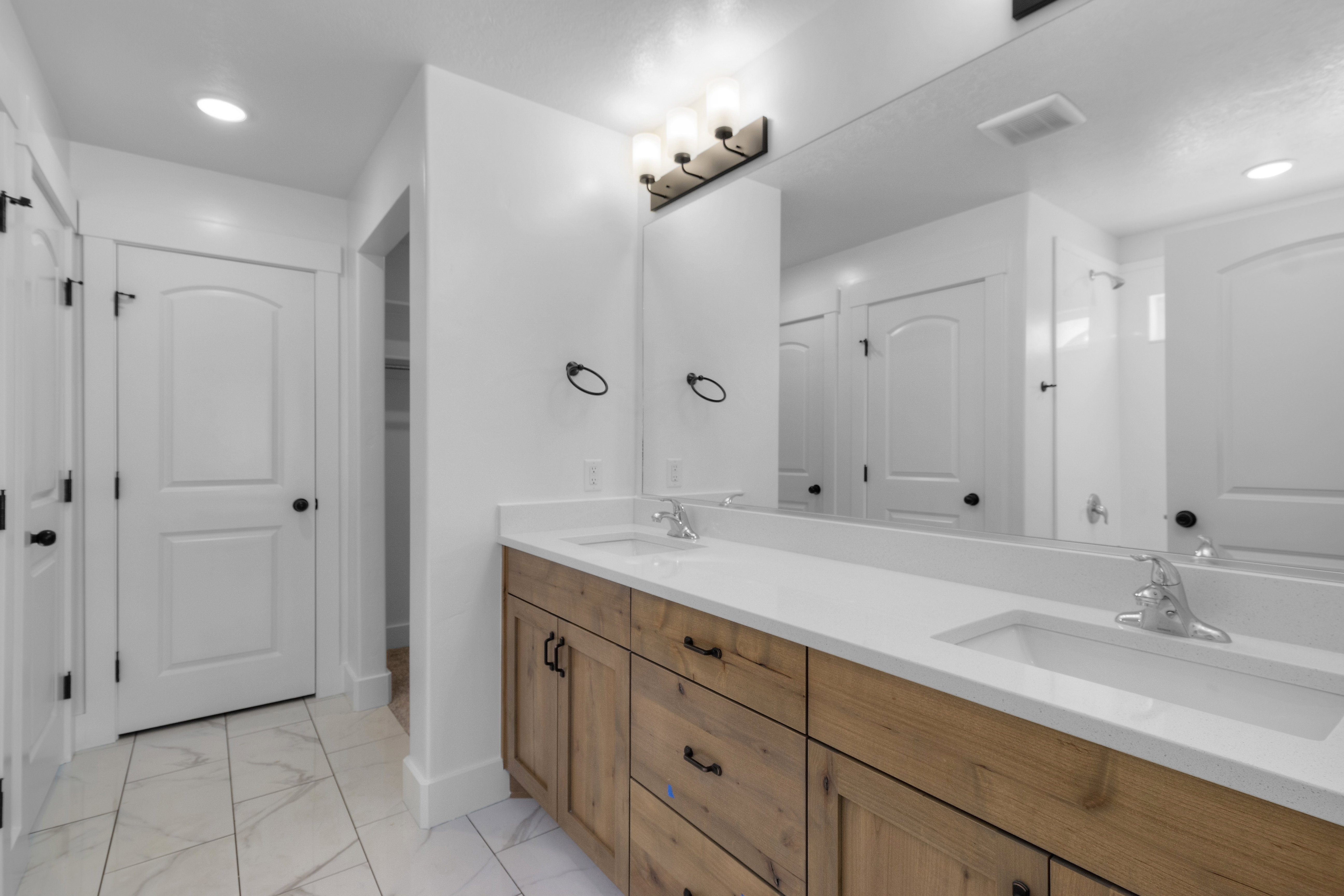 Full bathroom with recessed lighting, double vanity, a closet, and light marble finish floors