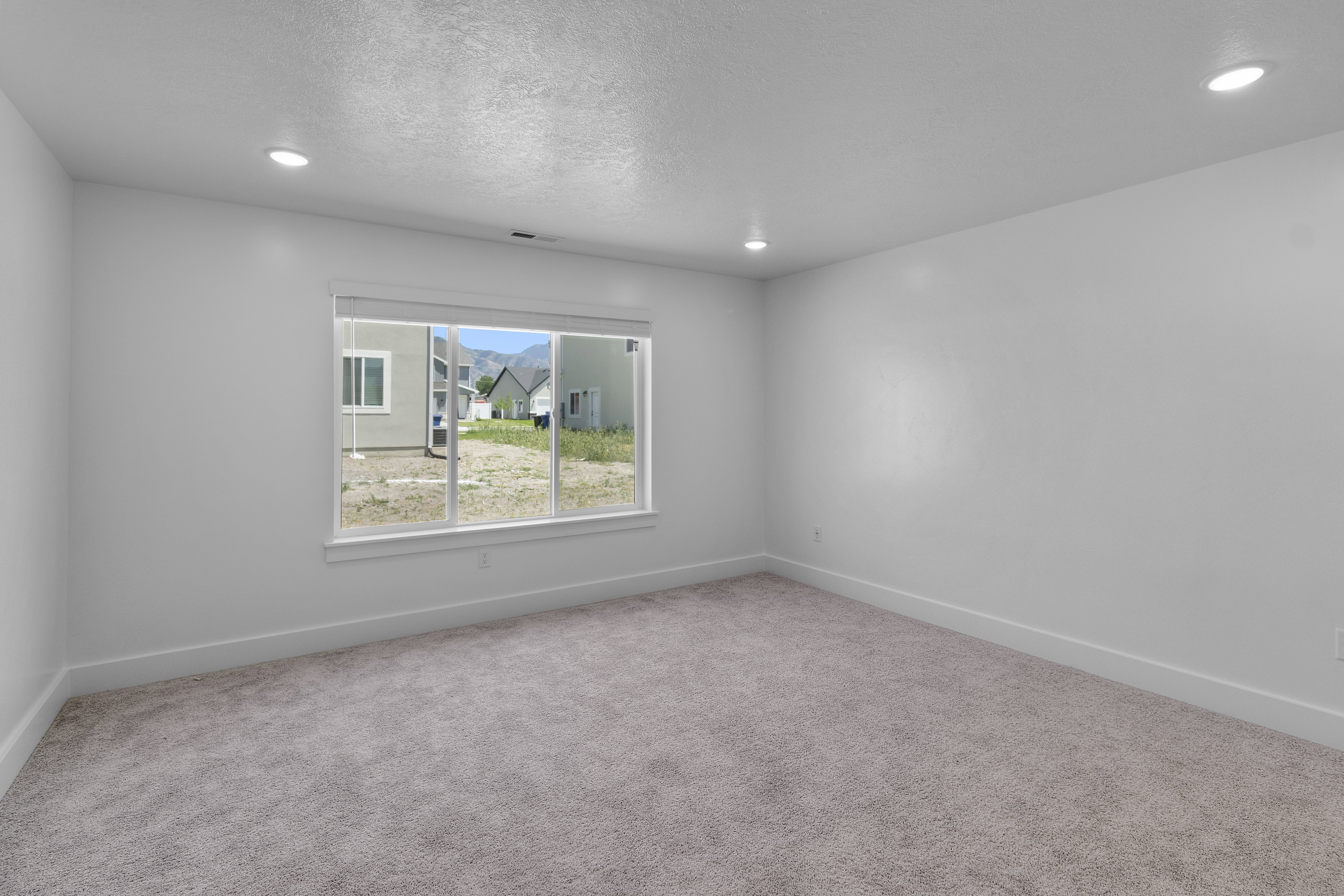 Spare room featuring carpet, recessed lighting, and a textured ceiling