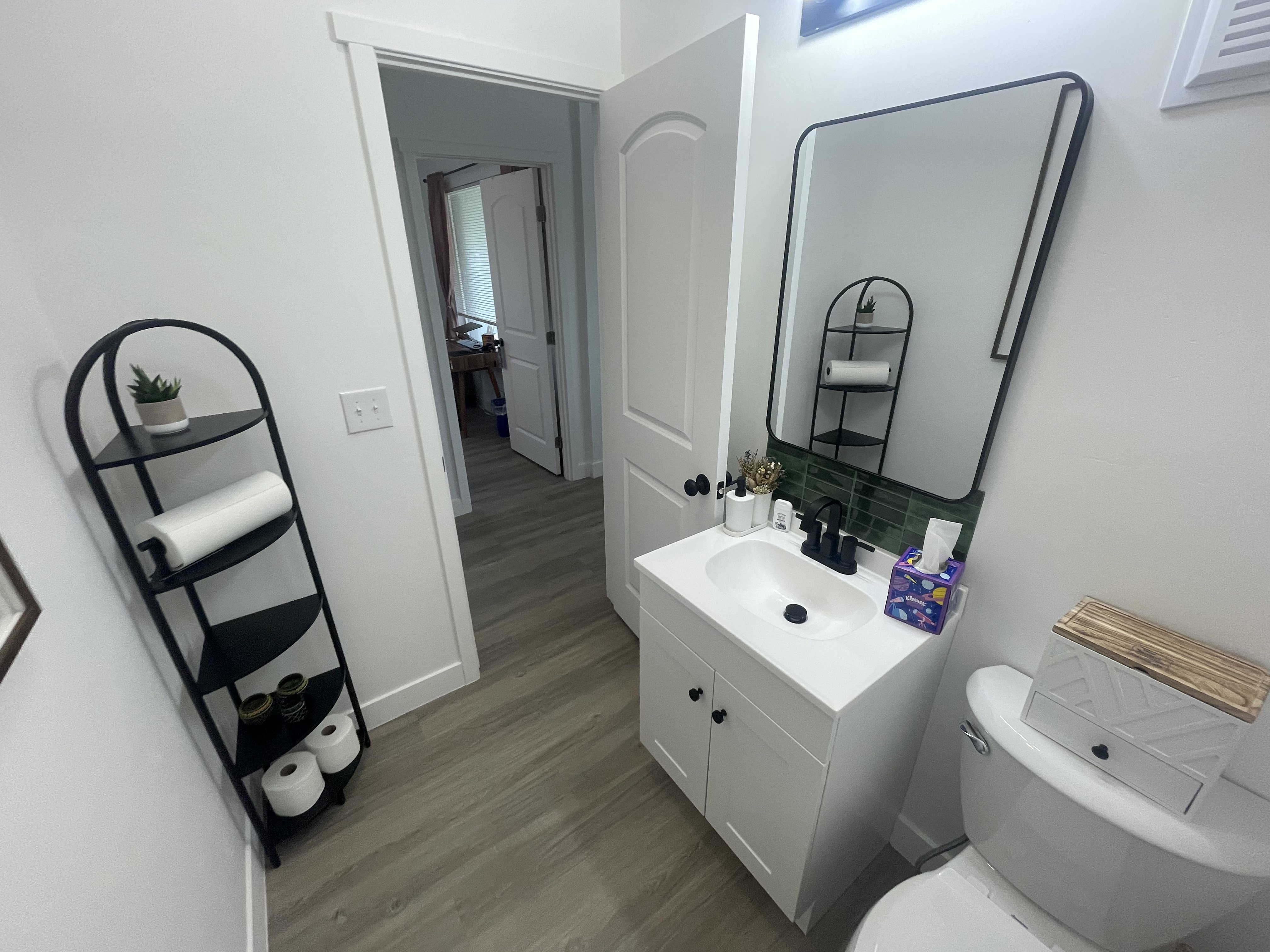Half bathroom featuring vanity, dark wood-style flooring, and backsplash