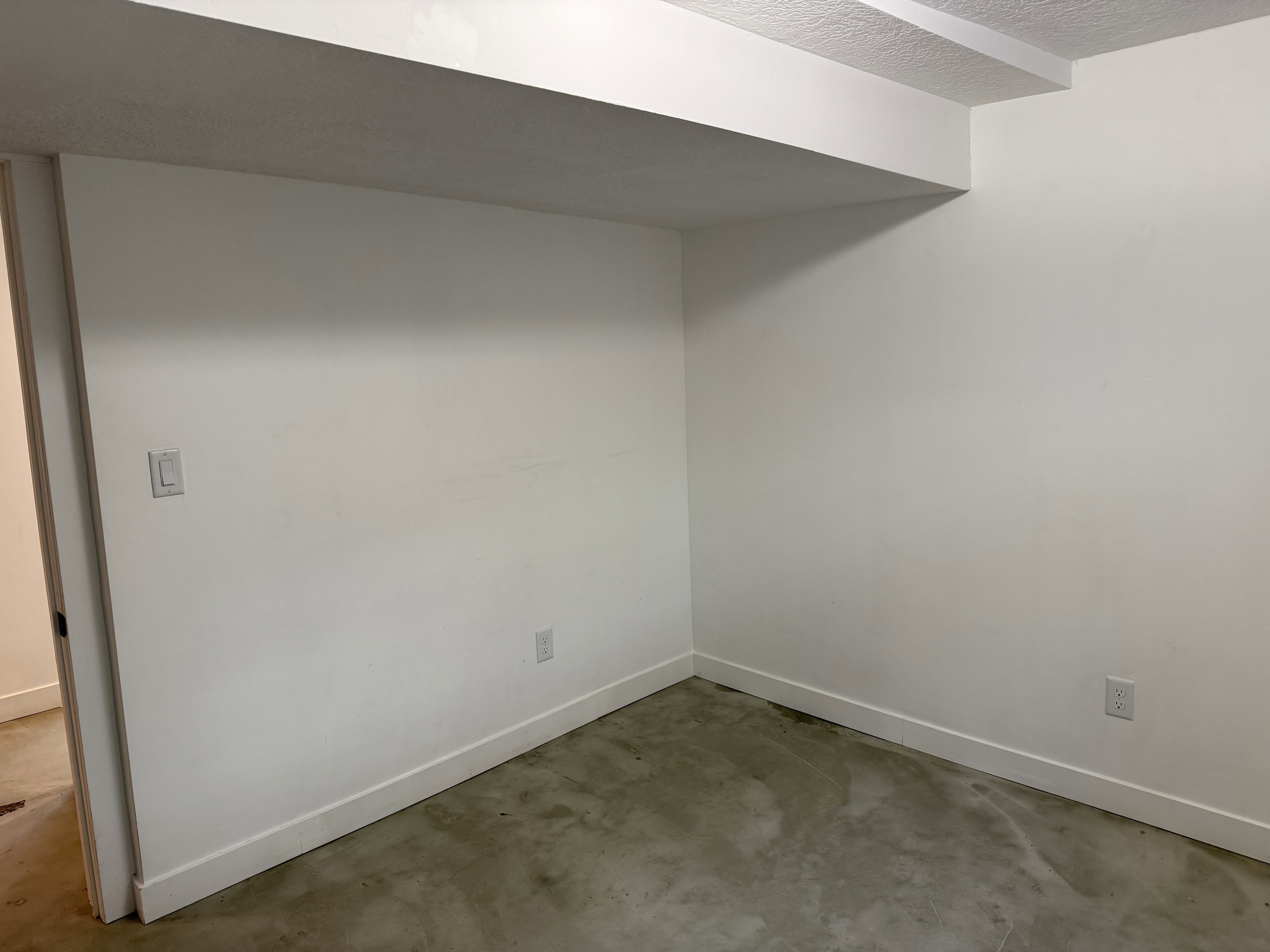 Unfurnished room with concrete flooring and a textured ceiling