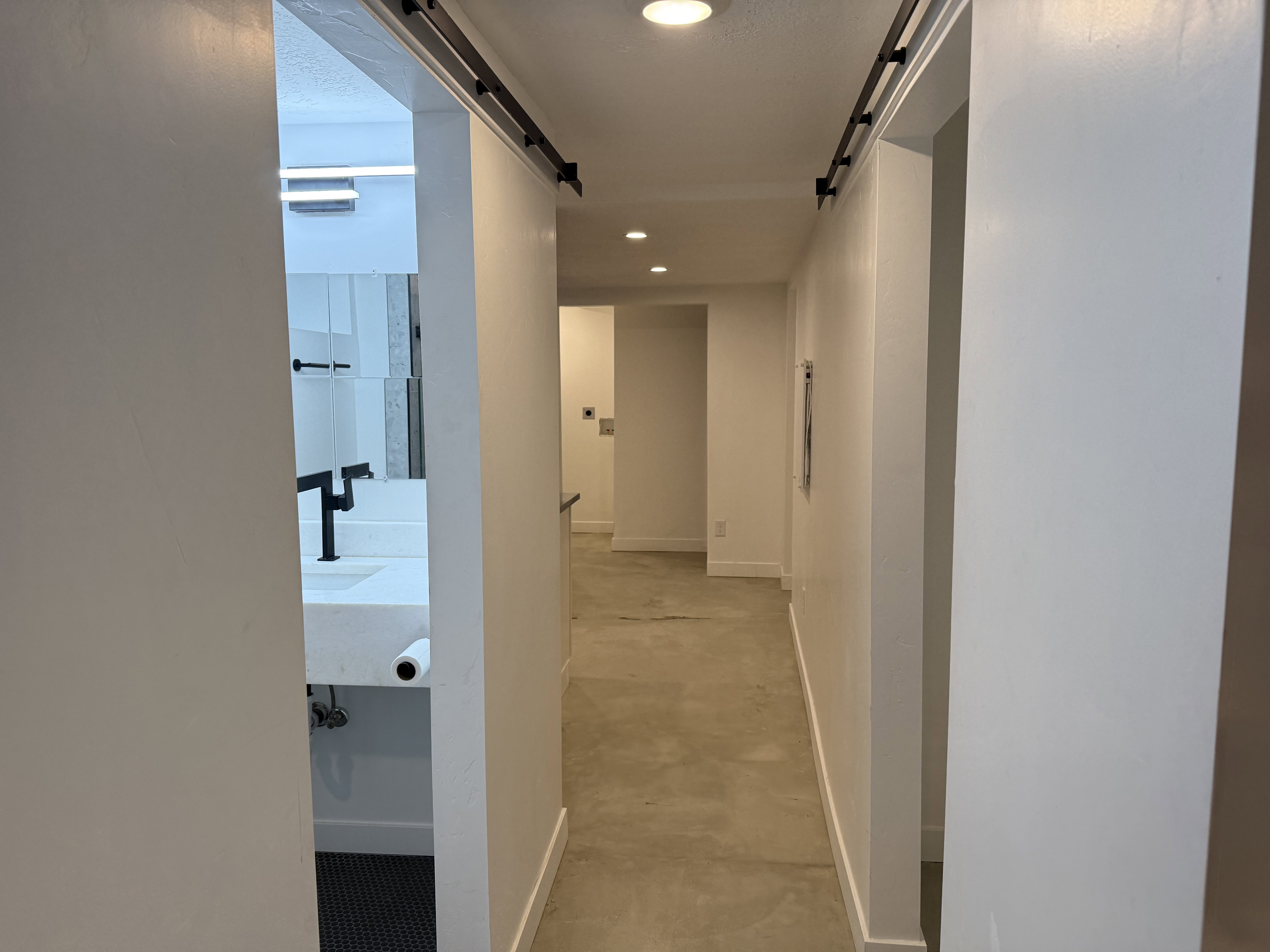 Corridor featuring a barn door and recessed lighting