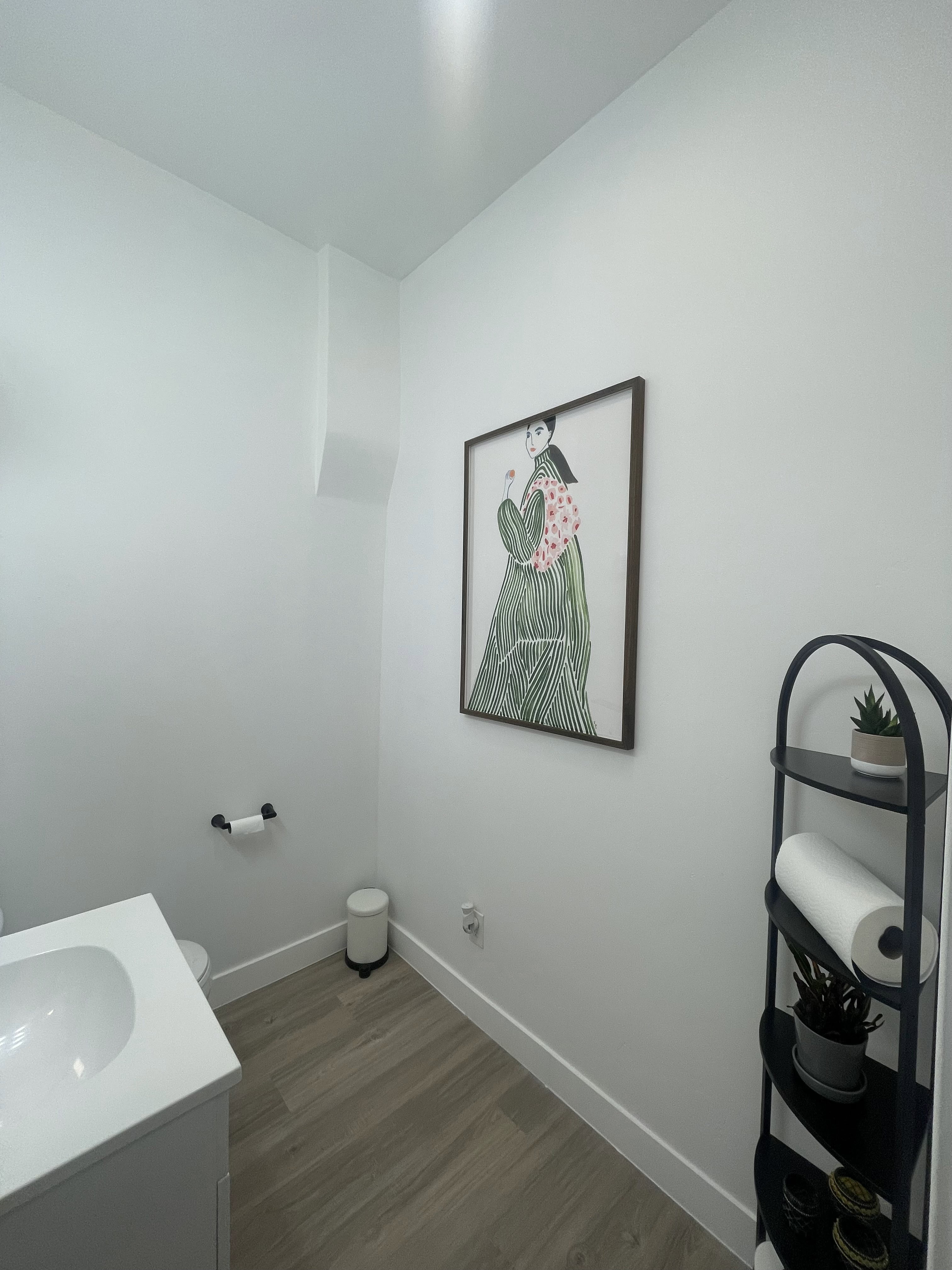 Half bathroom with vanity and dark wood-style floors