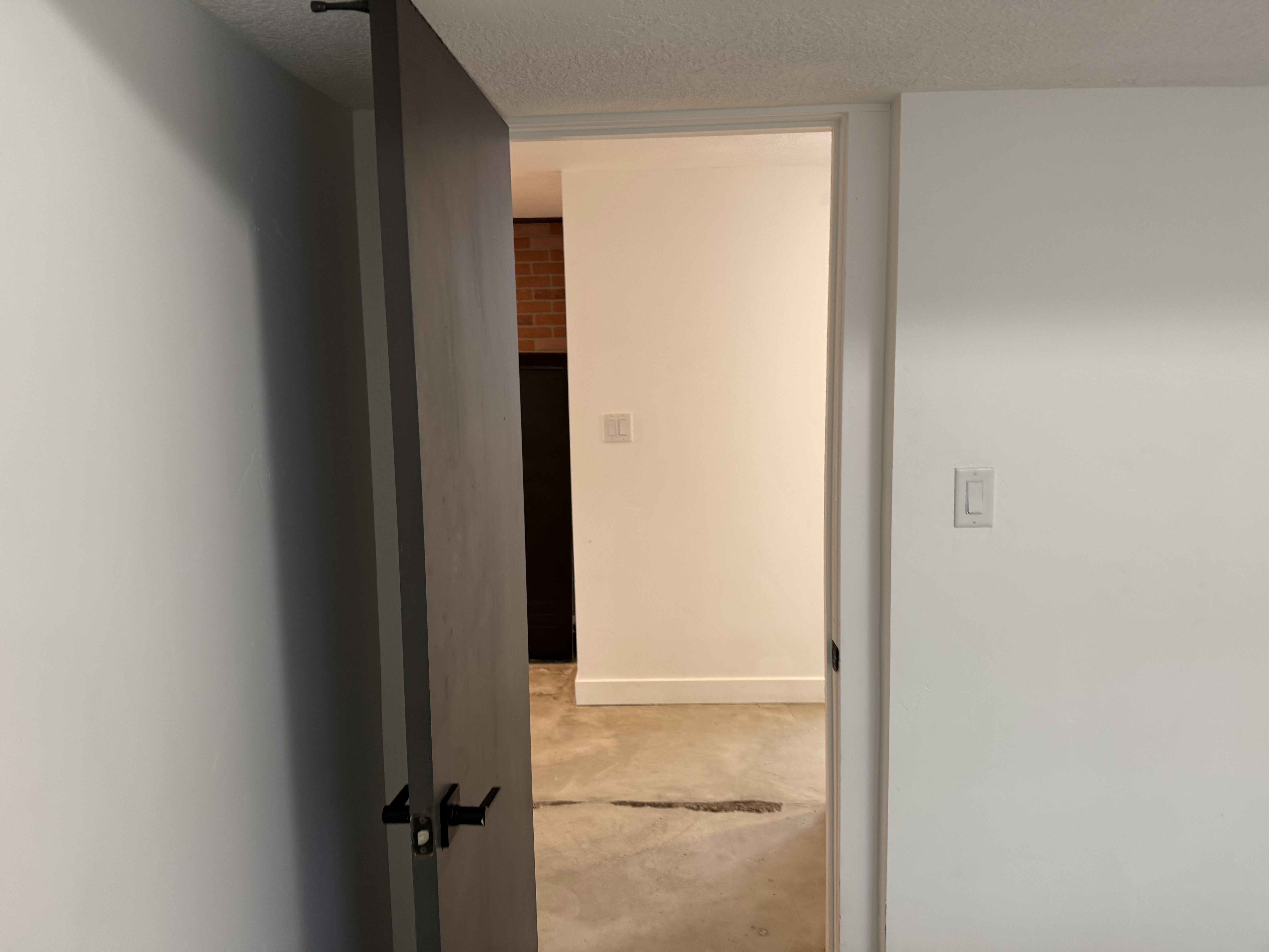 Hallway featuring a textured ceiling and baseboards