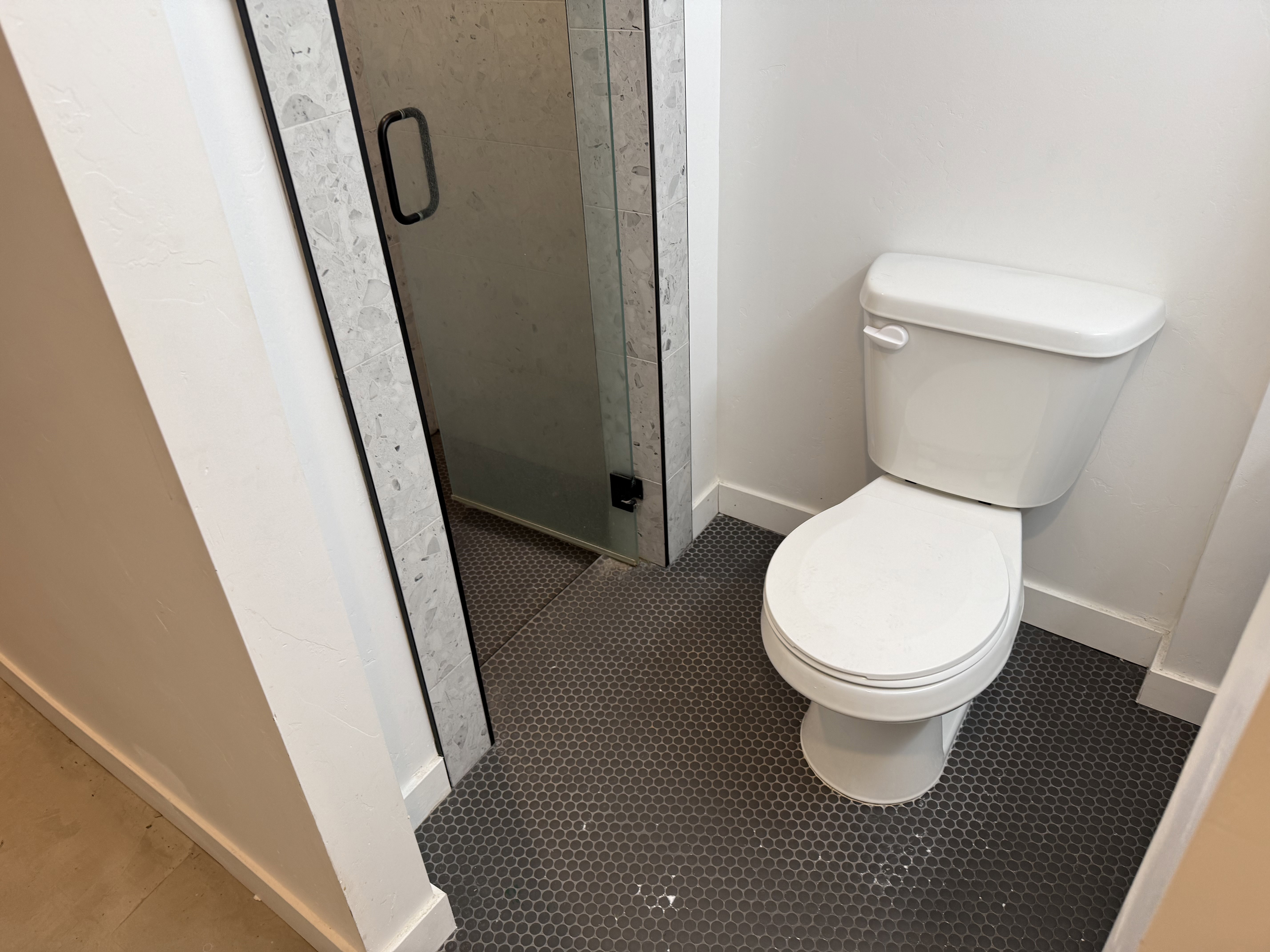 Bathroom featuring baseboards and a shower stall
