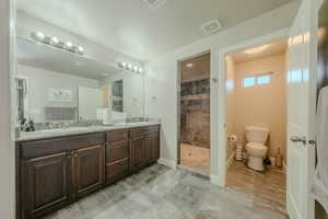 Full bathroom with double vanity, a walk in shower, and light marble finish flooring