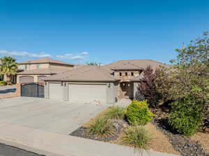View of front of property with stucco siding, a garage, and driveway