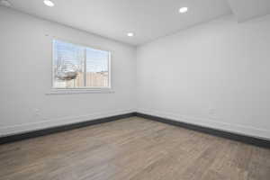 Unfurnished room featuring dark wood-type flooring, recessed lighting, and a smoke detector
