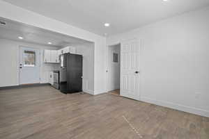Kitchen featuring white cabinetry, freestanding refrigerator, dark wood-style floors, recessed lighting, and stainless steel electric range oven