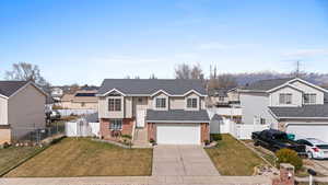Split foyer home featuring a gate, a residential view, driveway, and brick siding