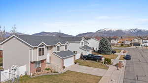 View of front of house with a residential view, brick siding, concrete driveway, and a mountain view