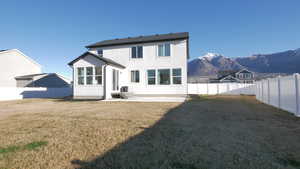 Rear view of house featuring a patio, a  fully fenced backyard, and a mountain view