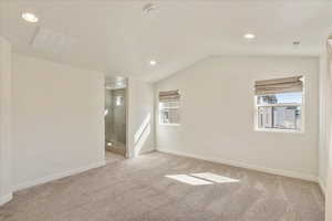 Unfurnished room featuring vaulted ceiling, light carpet, and recessed lighting