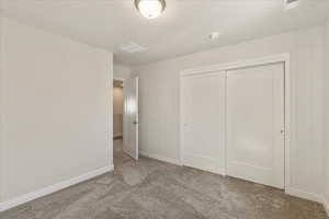 Unfurnished bedroom featuring carpet and a closet
