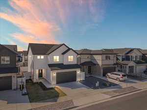 View of front of property with a residential view, driveway, an attached garage, and board and batten siding