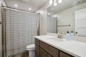 Full bathroom with vanity, curtained shower, and a textured ceiling