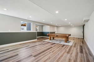 Game room with pool table, light wood-style flooring, a wainscoted wall, recessed lighting, and a textured ceiling