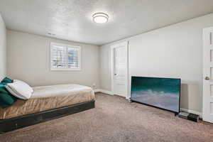 Bedroom featuring a textured ceiling and carpet flooring