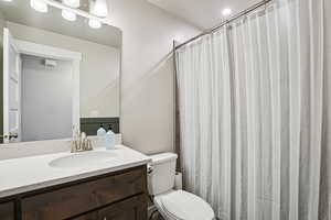 Bathroom featuring a shower with curtain and vanity