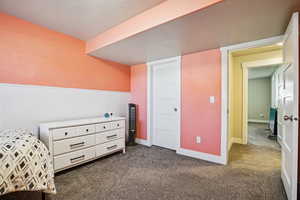 Bedroom featuring a textured ceiling and dark colored carpet
