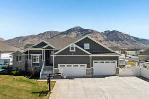 Craftsman house with a gate, board and batten siding, a mountain view, and concrete driveway