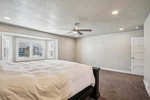 Bedroom featuring dark colored carpet, recessed lighting, a ceiling fan, and a textured ceiling