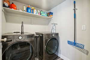 Laundry room with washing machine and clothes dryer and wood finished floors