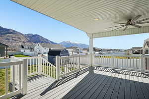 Wooden deck featuring a residential view, a ceiling fan, and a mountain view