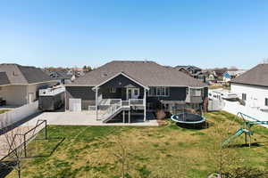 Rear view of house with a residential view, a patio area, a trampoline, and a fenced backyard