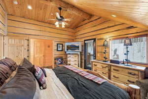 Bedroom with recessed lighting, a high wood beamed ceiling, and wooden walls
