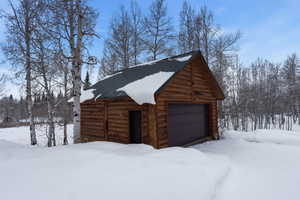 Snow covered garage featuring a garage