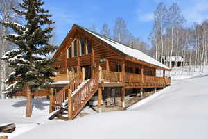 View of snow covered exterior with a porch and stairs