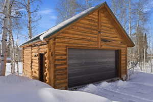 Snow covered garage with a garage