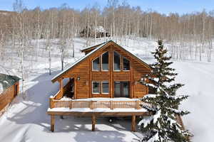 Snow covered property with a deck