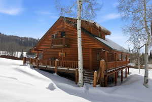 View of snowy exterior with a porch