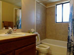 Bathroom featuring vanity and shower / bathtub combination with curtain