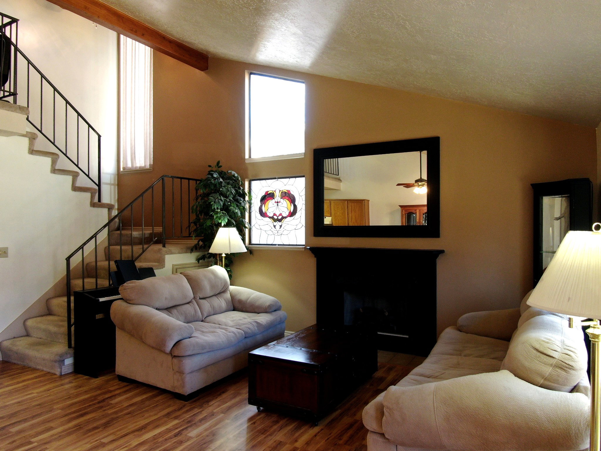 Living area with a fireplace, dark wood finished floors, and a high textured ceiling