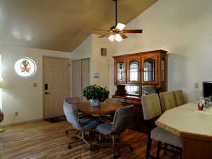 Dining space featuring lofted ceiling, wood finished floors, and ceiling fan